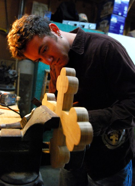 Nicholas Souder files down the weight he installed on a wooden cross that will be thrown into the Spring Bayou on Epiphany Day in Tarpon Springs. For 40 years Souder's grandfather has made the crosses. He has trained Souder to carry on the family tradition, and this was his first year.